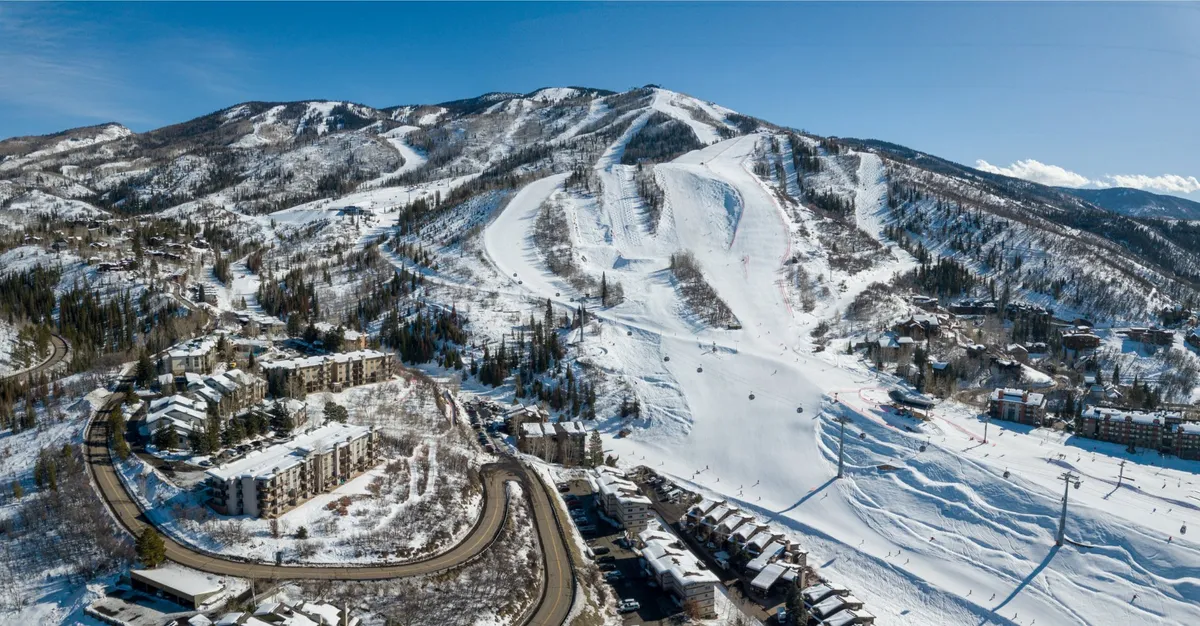 A panoramic outdoor scene showcasing ski lifts gliding up snow-packed mountains, surrounded by serene trees and cozy residential buildings. The morning light highlights the tranquil atmosphere and the inviting appeal of the area.